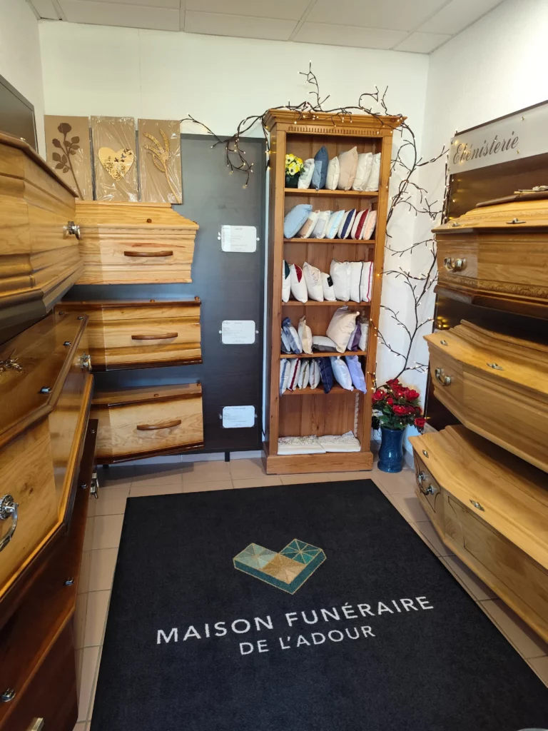 Salle d'exposition de cercueils en bois et capitons dans une entreprise funéraire.