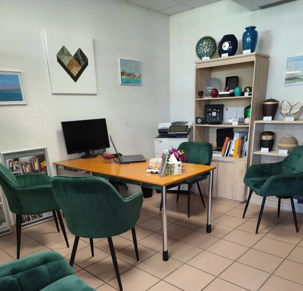 Bureau d'accueil funéraire chaleureux avec fauteuils verts pour recevoir les familles.